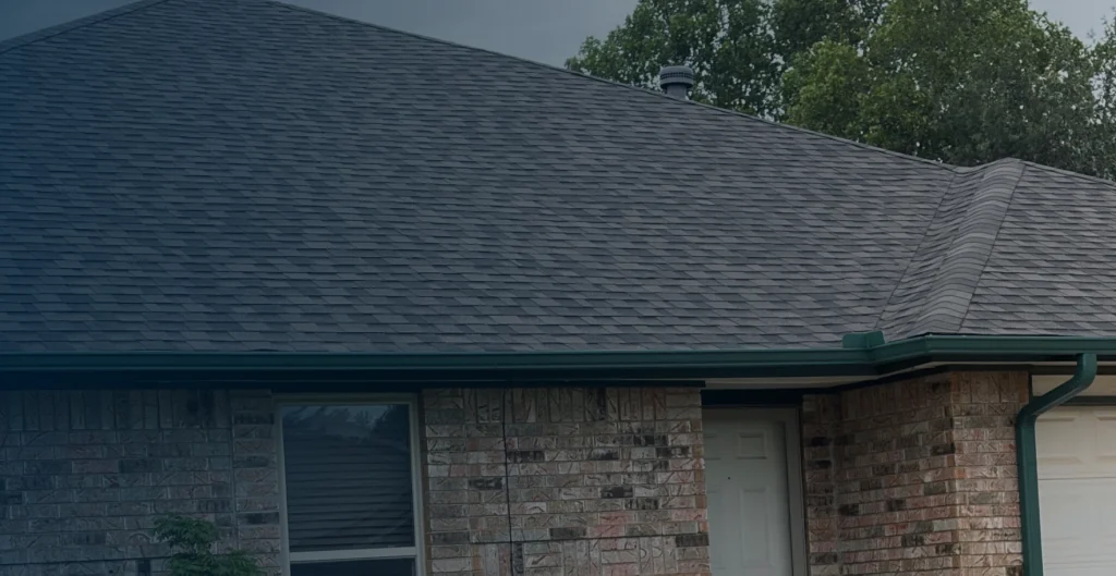 Residential home with dark shingles and brick exterior
